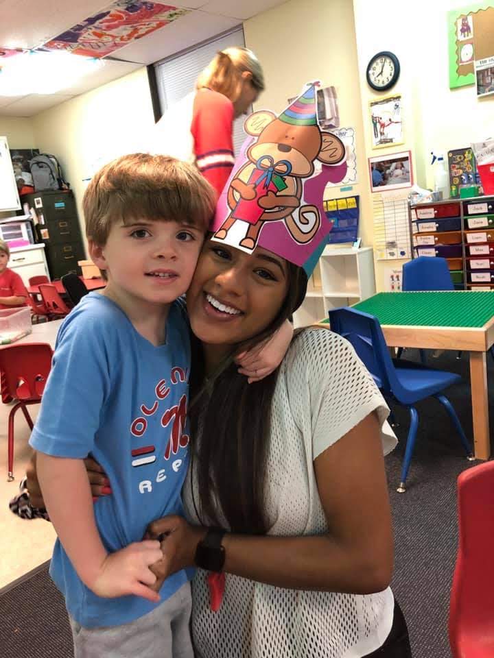 Reyes poses for a photo with a student from the HILL Program.