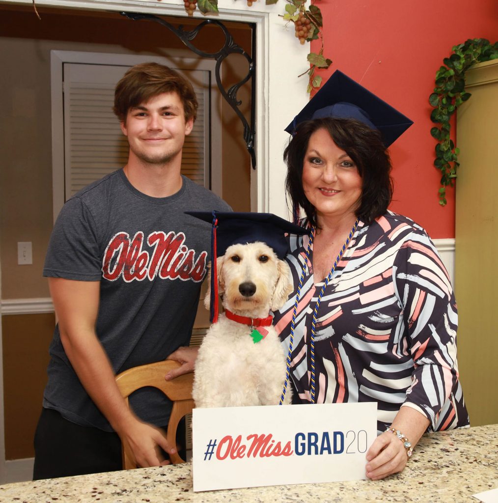 Michelle Adcox, her son Ben and Ben's dog, Lady, pose for a photo in their home.