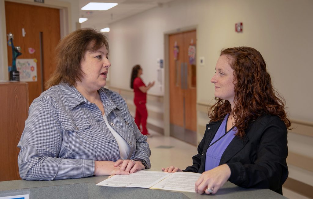 Elicia King, right, shift supervisor, reviews paperwork with Farris.