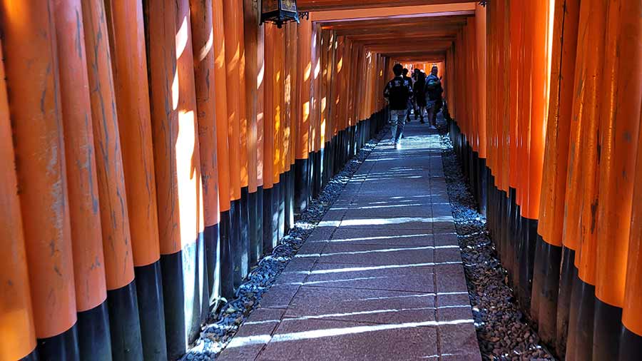 Photo of receding walkway up Mt. Inari. Group of people with backpacks on in background.