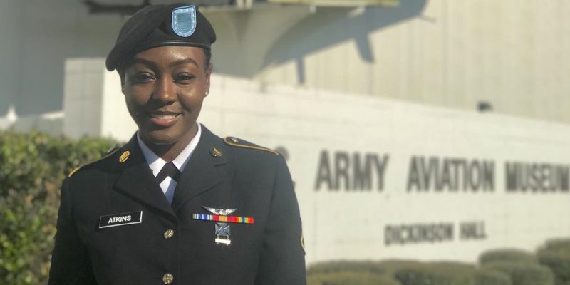 Tishira stands in a military uniform in front of the U.S. Army Aviation Museum.