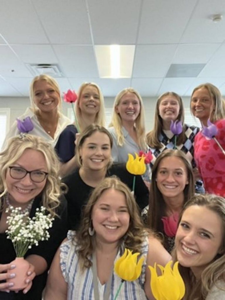 Abby Newton and other special education students pose with paper flowers to celebrate their graduation.