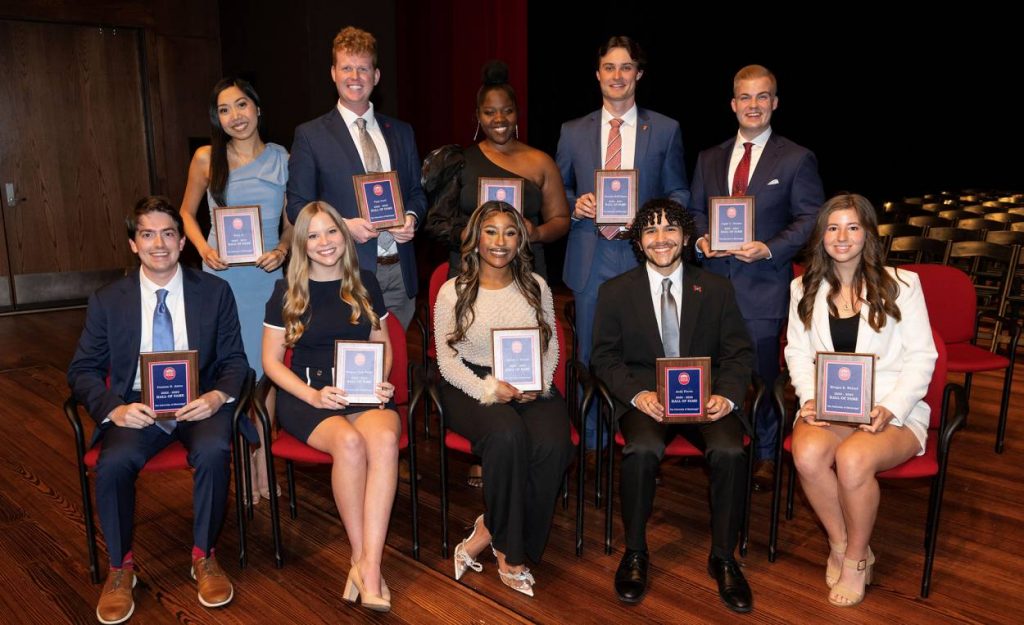 Jilkiah sits on stage with 9 other students who were in the Hall of Fame.