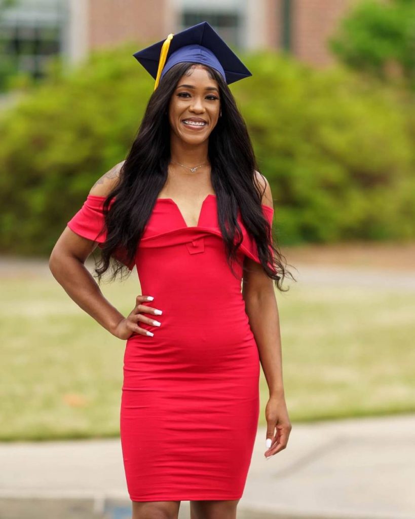 Orianna stands outside in a red dress with a blue graduation cap with a yellow tassel.
