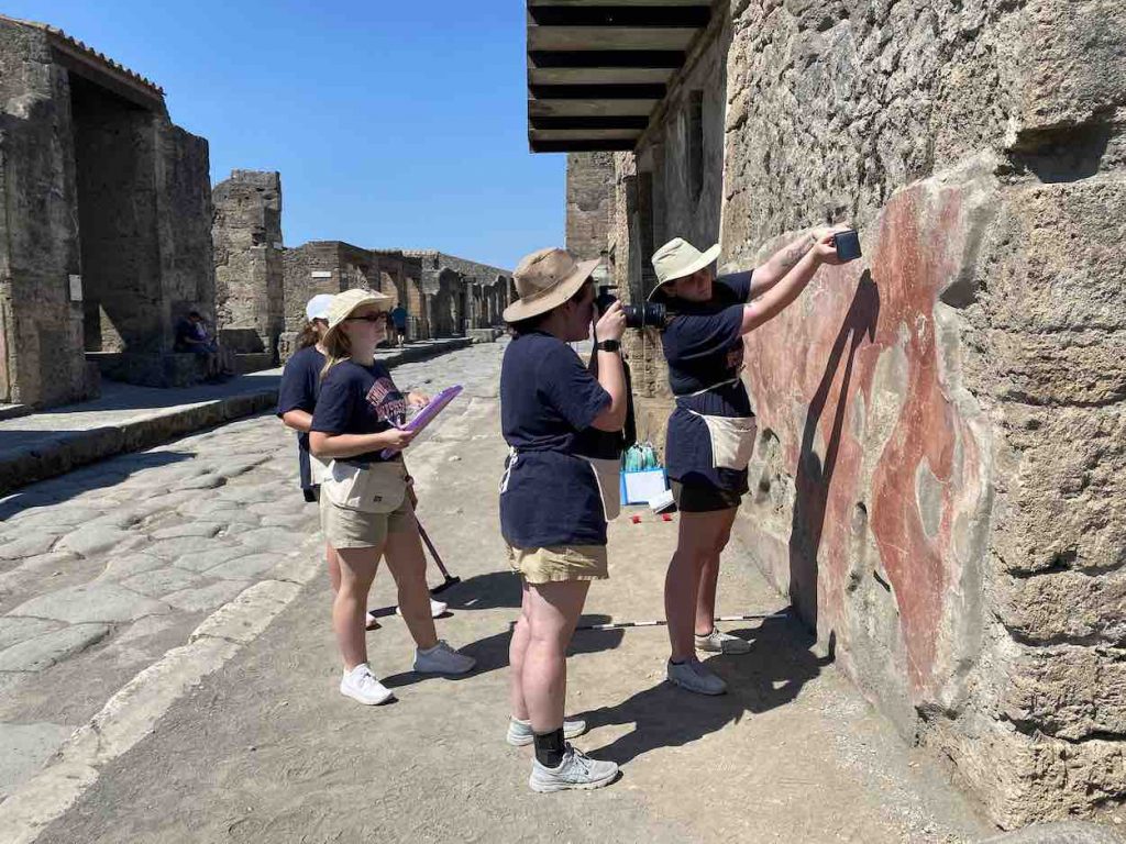 Harris and her group extensively photographing graffiti in Pompeii in order to document it.